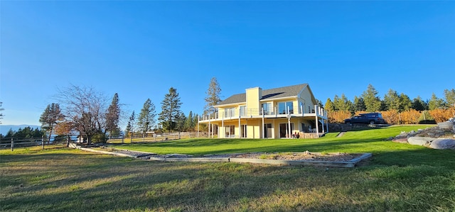 back of property featuring a wooden deck and a lawn