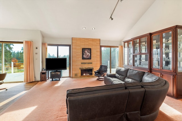 carpeted living room featuring high vaulted ceiling and a tile fireplace