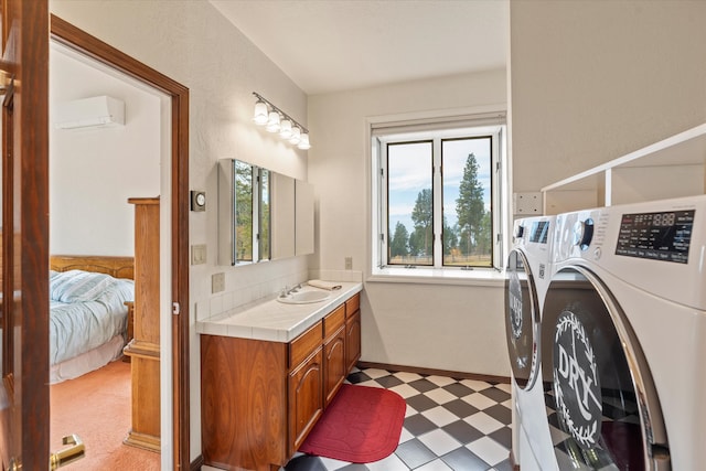 bathroom with a wall mounted air conditioner, vanity, and washer and clothes dryer