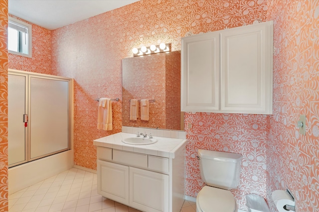 full bathroom featuring combined bath / shower with glass door, tile patterned floors, vanity, and toilet