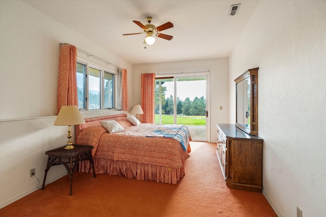 carpeted bedroom featuring access to outside, multiple windows, and ceiling fan