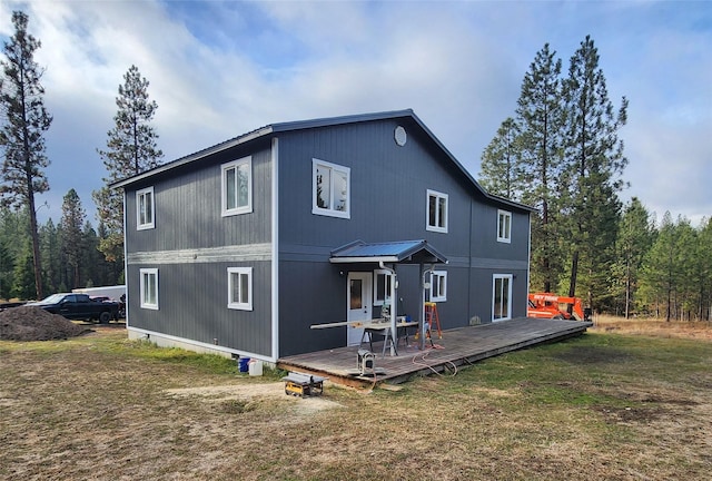 back of property featuring a wooden deck and a yard