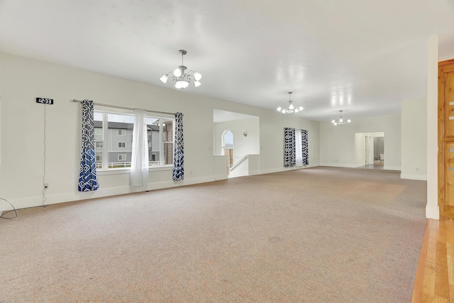 unfurnished living room featuring carpet floors and a chandelier