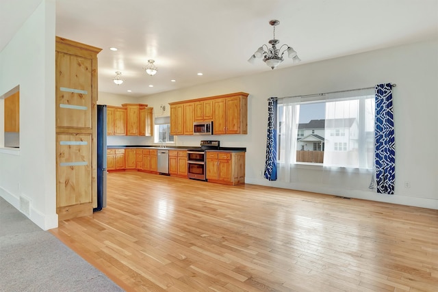 kitchen with pendant lighting, a notable chandelier, light hardwood / wood-style floors, and appliances with stainless steel finishes