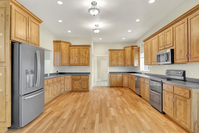 kitchen featuring appliances with stainless steel finishes, light wood-type flooring, and sink