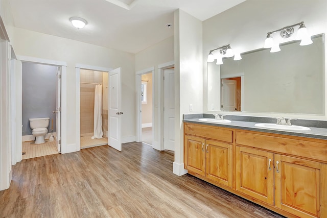 bathroom featuring hardwood / wood-style flooring, vanity, toilet, and walk in shower