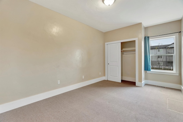 unfurnished bedroom with light carpet and a closet