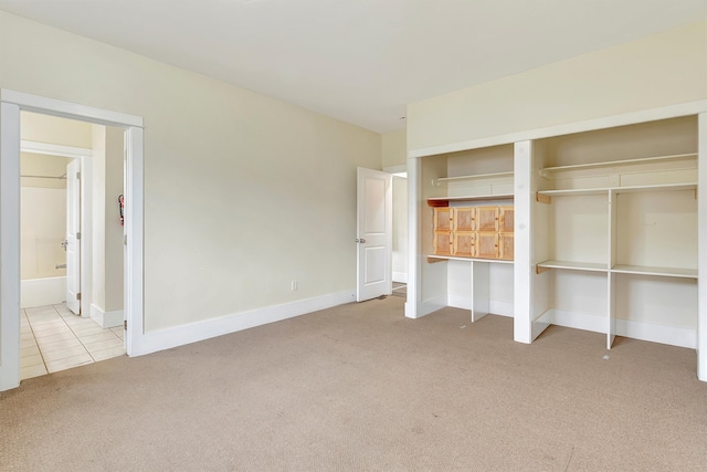 unfurnished bedroom featuring light colored carpet and a closet