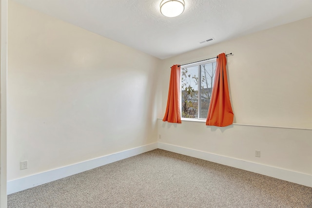 carpeted empty room featuring a textured ceiling