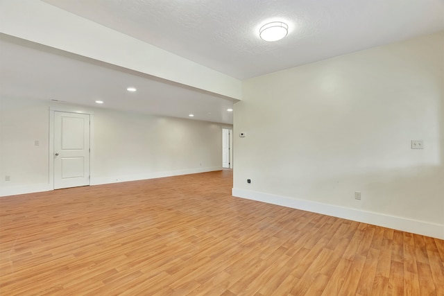 empty room featuring light hardwood / wood-style floors and a textured ceiling