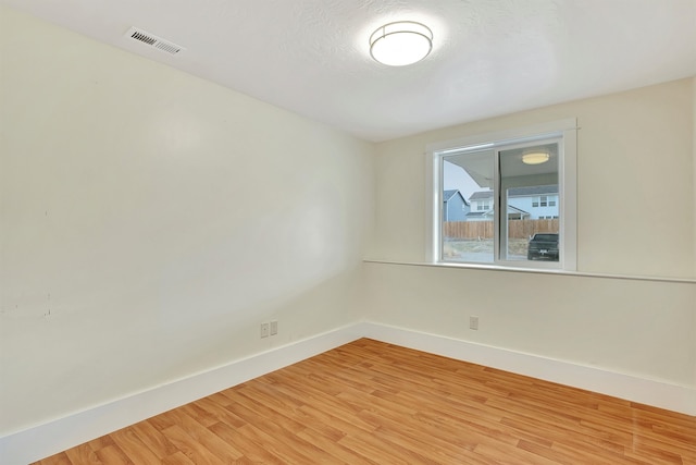 spare room with hardwood / wood-style floors and a textured ceiling