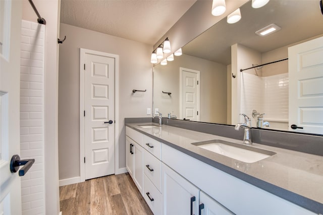 bathroom featuring vanity, hardwood / wood-style flooring, shower / washtub combination, and a textured ceiling