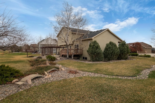 rear view of property featuring a lawn and a deck