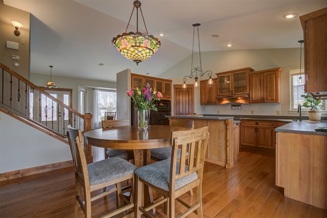 dining space with wood-type flooring, vaulted ceiling, and plenty of natural light