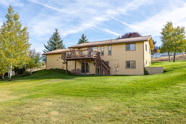 rear view of house featuring a lawn and a deck