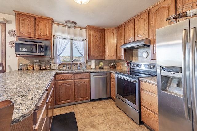 kitchen with stainless steel appliances, tasteful backsplash, dark stone counters, and sink