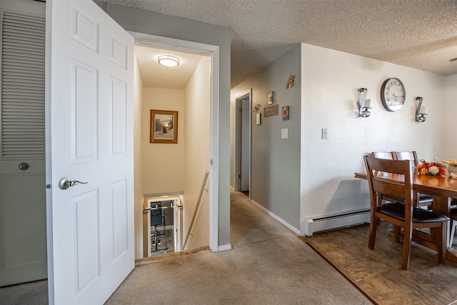 carpeted dining space featuring baseboard heating and a textured ceiling