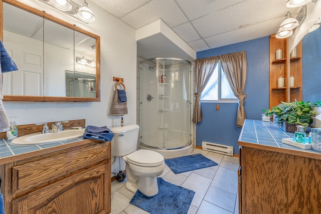 bathroom featuring tile patterned floors, a paneled ceiling, a shower with door, and baseboard heating