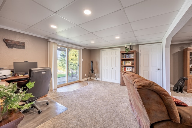 office space with light carpet, a paneled ceiling, and ornamental molding