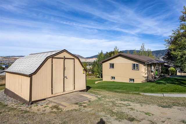 view of outbuilding with a lawn and a mountain view