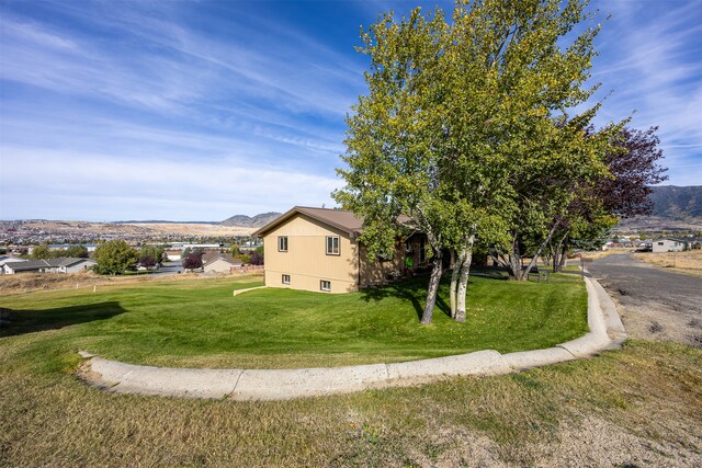 view of side of property with a lawn and a mountain view