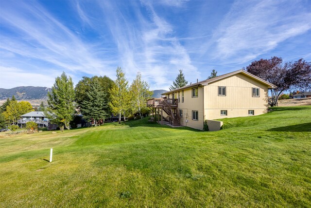 view of yard with a deck with mountain view