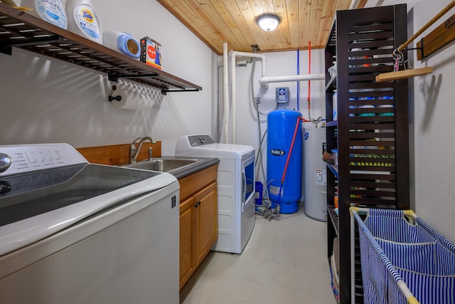 clothes washing area featuring washing machine and dryer, cabinets, sink, and wood ceiling