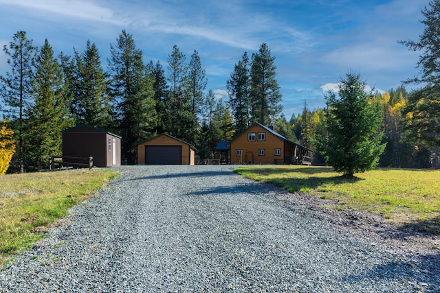 view of front of house with a garage, an outbuilding, and a front yard