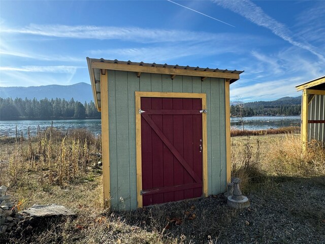 view of shed with a water and mountain view