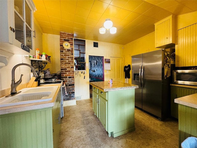 kitchen featuring appliances with stainless steel finishes, a center island, sink, and green cabinetry