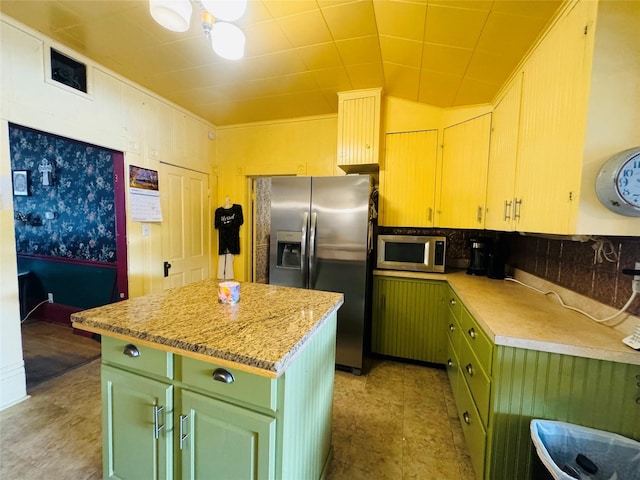 kitchen with stainless steel appliances, green cabinets, and a kitchen island