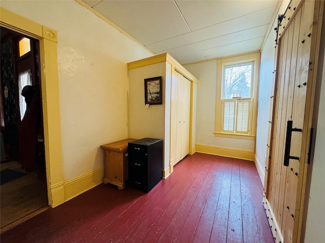 interior space with dark hardwood / wood-style flooring and a barn door