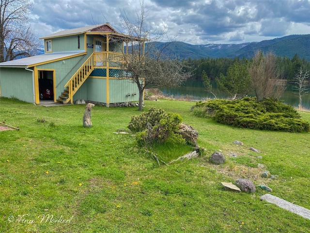 view of yard with a deck with water view