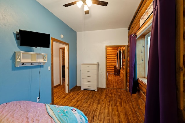 bedroom with ceiling fan, a spacious closet, dark hardwood / wood-style floors, lofted ceiling, and a closet