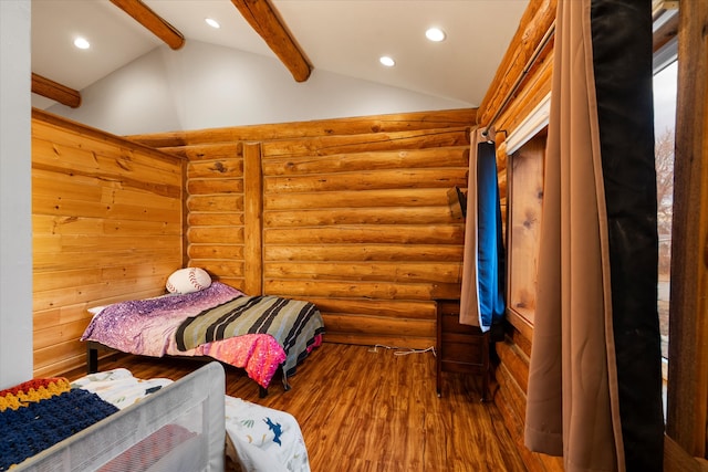 bedroom with vaulted ceiling with beams, hardwood / wood-style flooring, and rustic walls