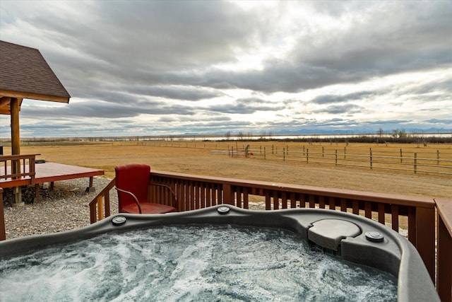 deck with a rural view and a hot tub