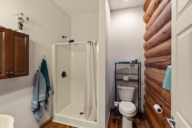 bathroom with toilet, wood-type flooring, and walk in shower