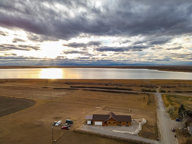 aerial view at dusk featuring a water view