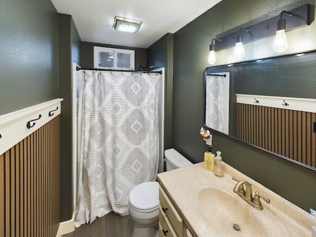 bathroom with walk in shower, vanity, and toilet