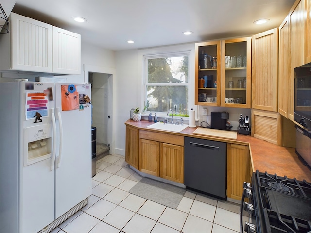 kitchen with black appliances, light tile patterned floors, and sink