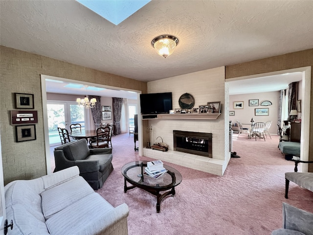 carpeted living room with a textured ceiling, a fireplace, and a chandelier