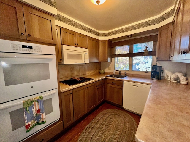 kitchen with white appliances, dark hardwood / wood-style floors, and sink