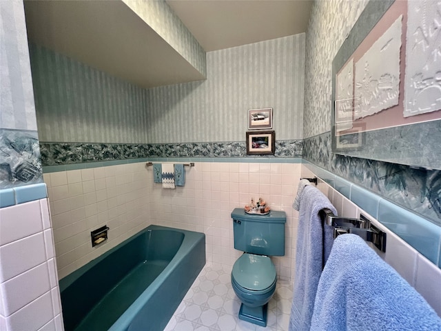 bathroom featuring a bathtub, toilet, and tile walls