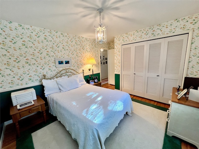 bedroom featuring a closet, dark hardwood / wood-style flooring, and ceiling fan with notable chandelier