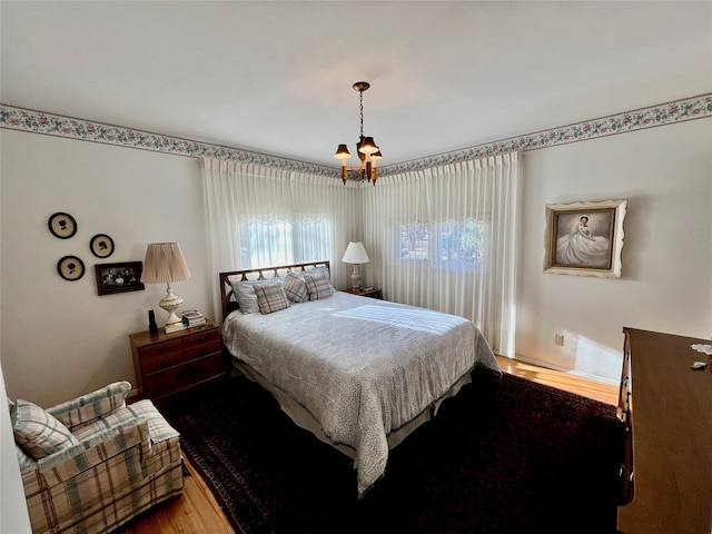 bedroom featuring hardwood / wood-style floors and a notable chandelier