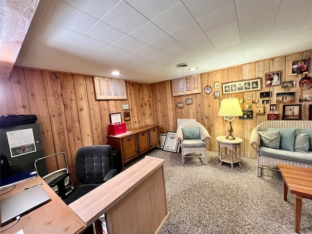 carpeted home office featuring wooden walls