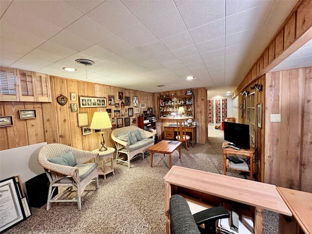 interior space with carpet, bar, and wood walls