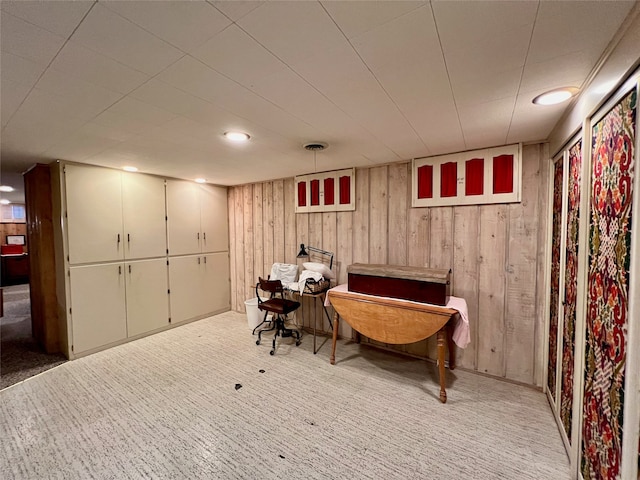 sitting room featuring carpet flooring and wooden walls