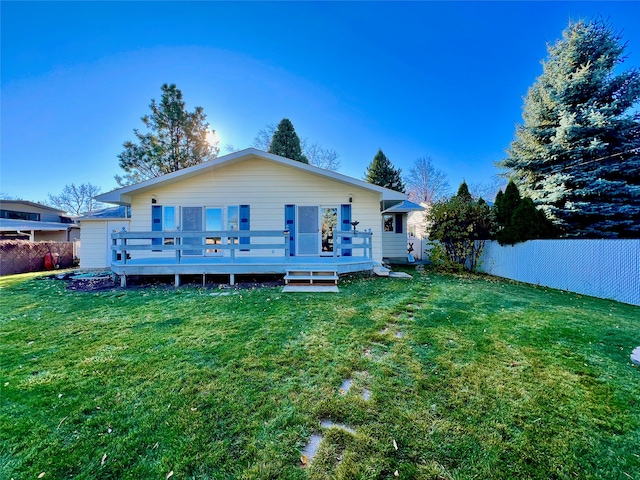 rear view of house featuring a yard and a deck