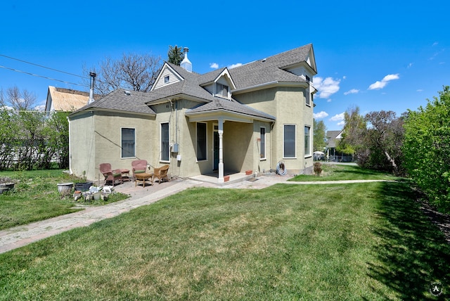 rear view of house with a yard and a patio